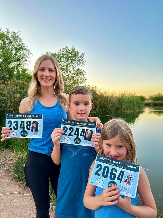Kristina, Luke, and Tyler holding fundraiser bibs for RP Hope event